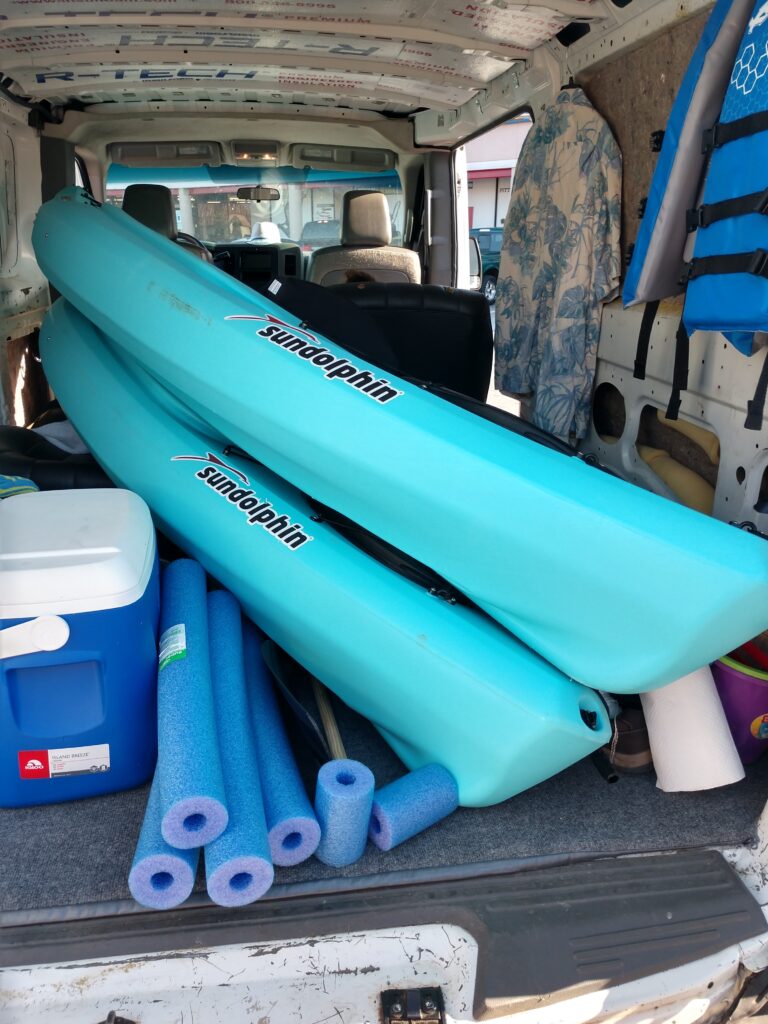 Kayaks and pool noodles in the back of the van