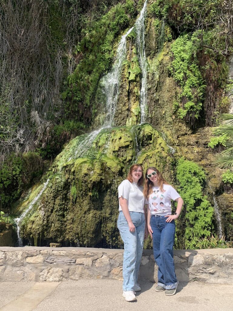 Two girls standing in front of a waterfall at the Japanese Friendship Garden in San Antonio