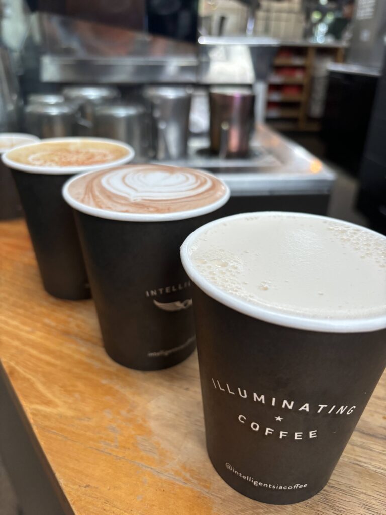 Three coffee cups on a wooden table looking from the side