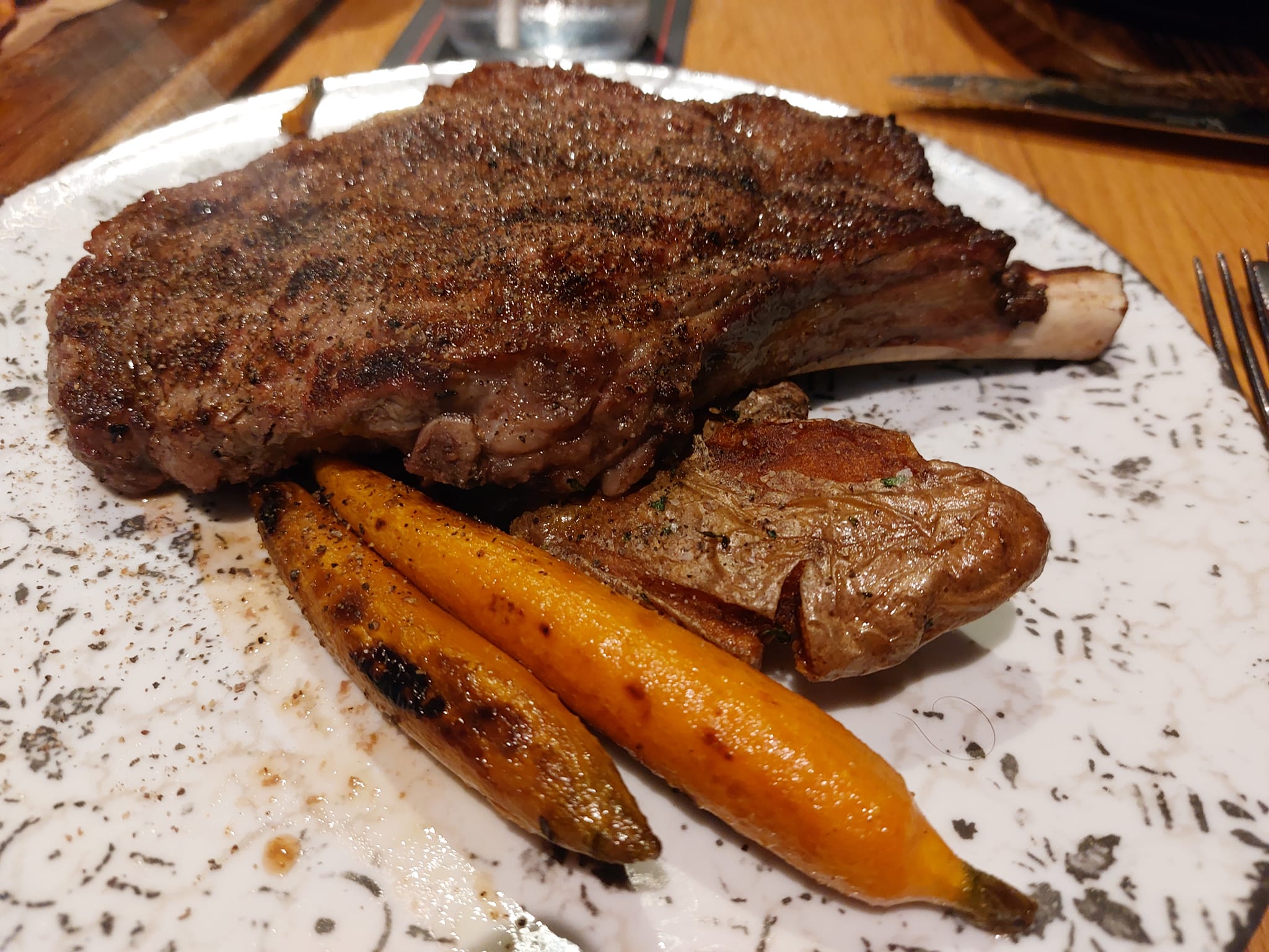 A steak sitting on top of some charred carrots