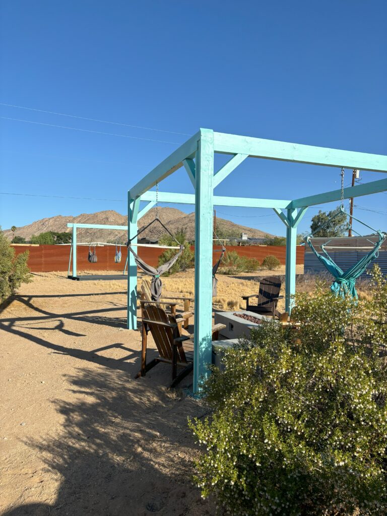 A blue patio area with several hammocks in Joshua Tree, CA