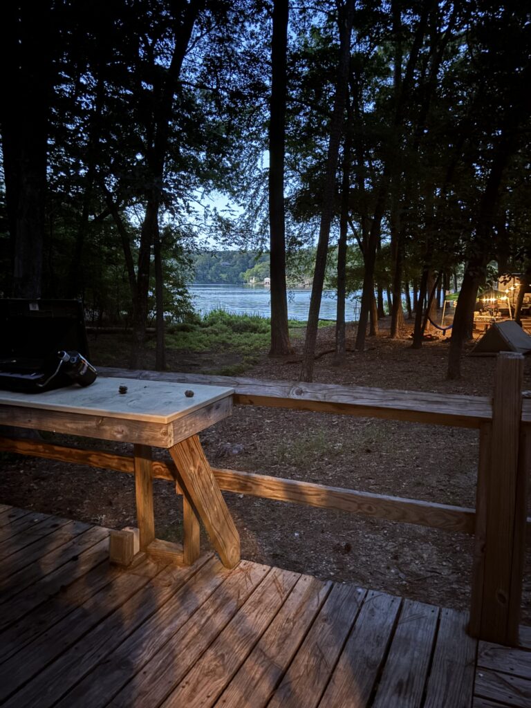 A cook table on a porch overlooking a lake