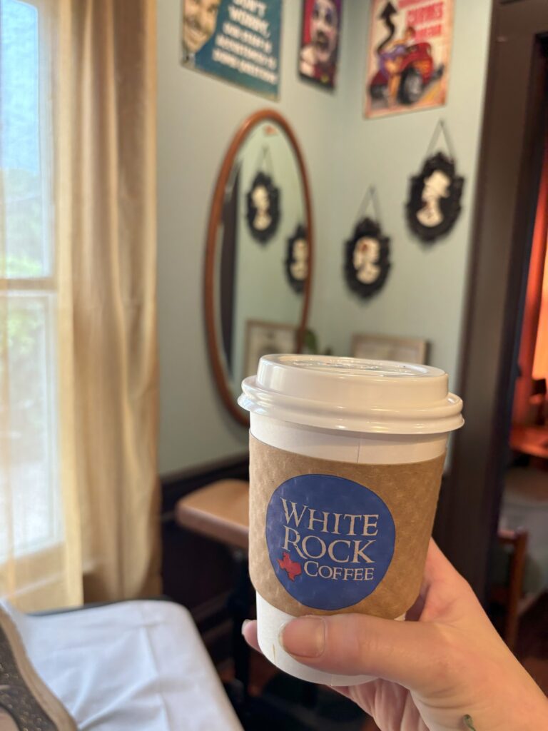 A coffee cup with a white rock coffee sleeve