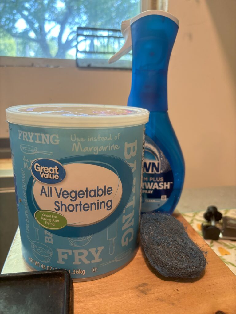 Vegetable shortening, dawn dish soap, and a wool scrubby waiting to be used on a cast iron griddle