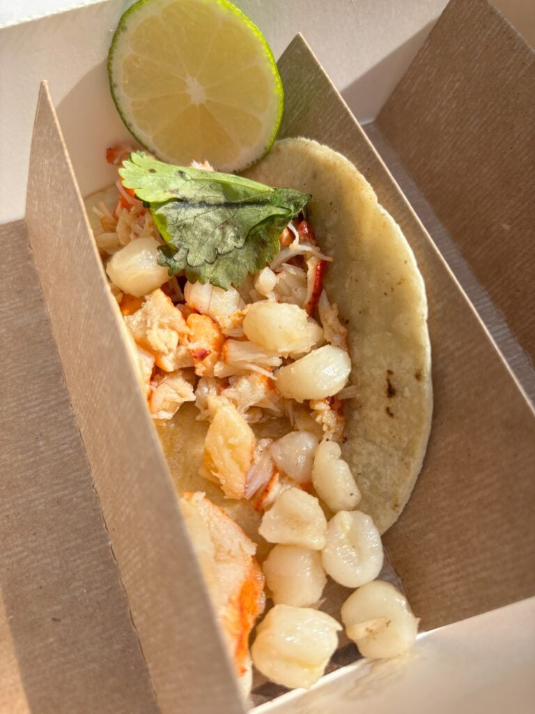 Warm lobster taco with hominy in it