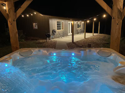 A hot tub over looking a house with string lights