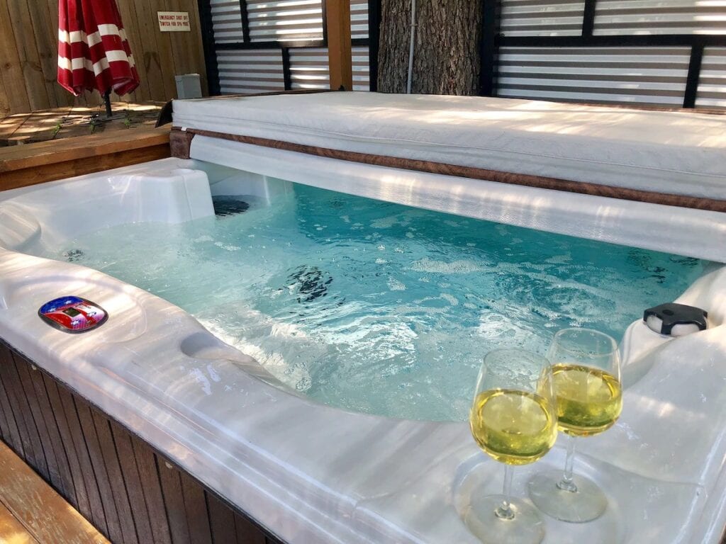 A hot tub with wine glasses sitting on it