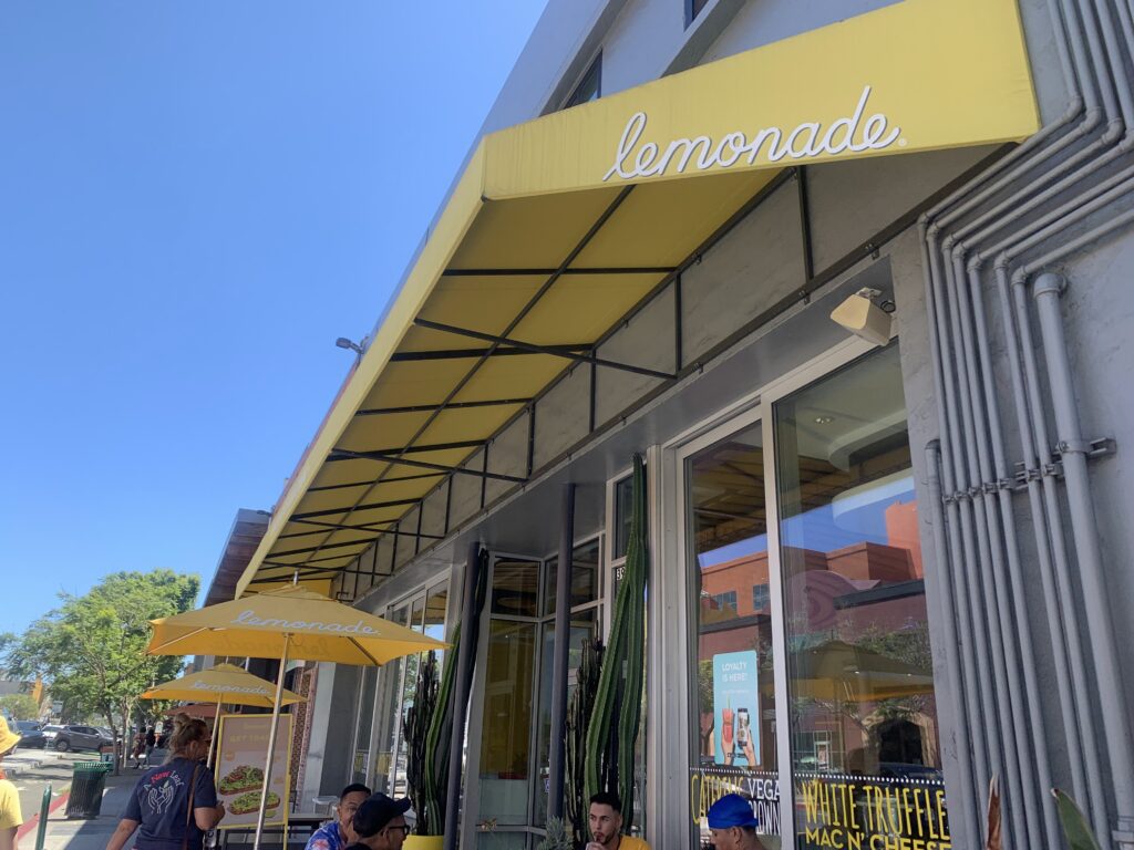 A yellow sign that says "lemonade" above a building