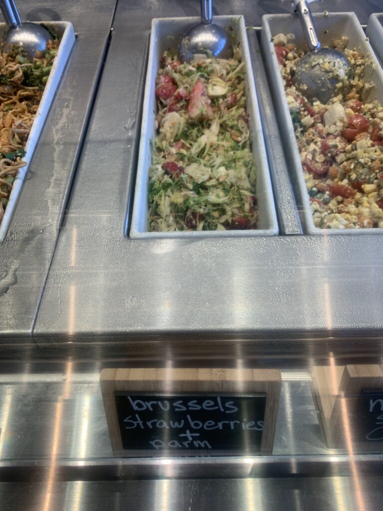 A stainless steel steam table with different food items on it