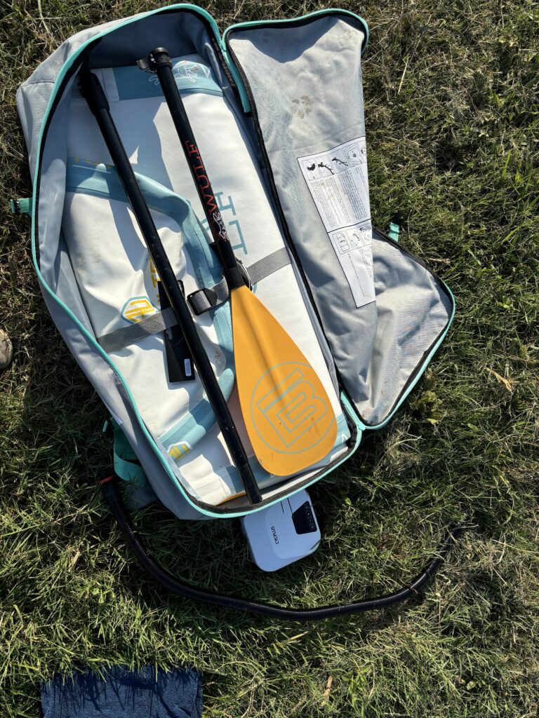 A folded up paddle board and paddle in a bag