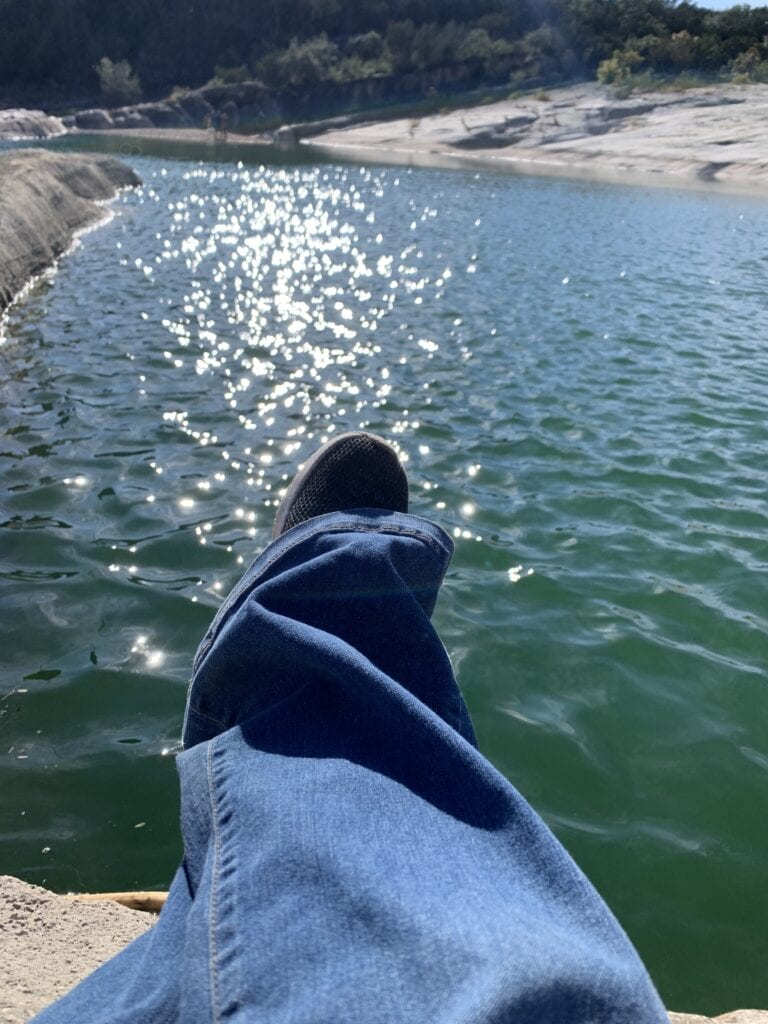 Looking at a pair of jeans and shoes over a creek bed