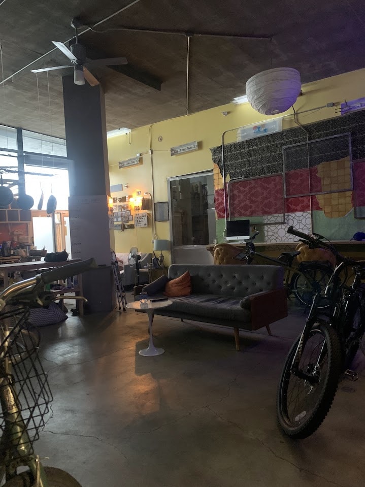 The Inside of a building with yellow walls and a bike in front right corner.