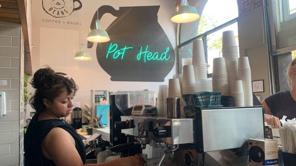 A giant coffee pot with a sign that says pot head lit up