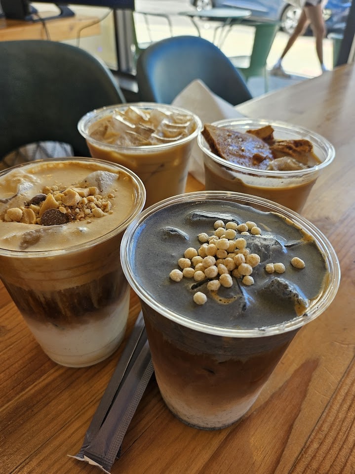 Four iced latte drinks sitting on a table