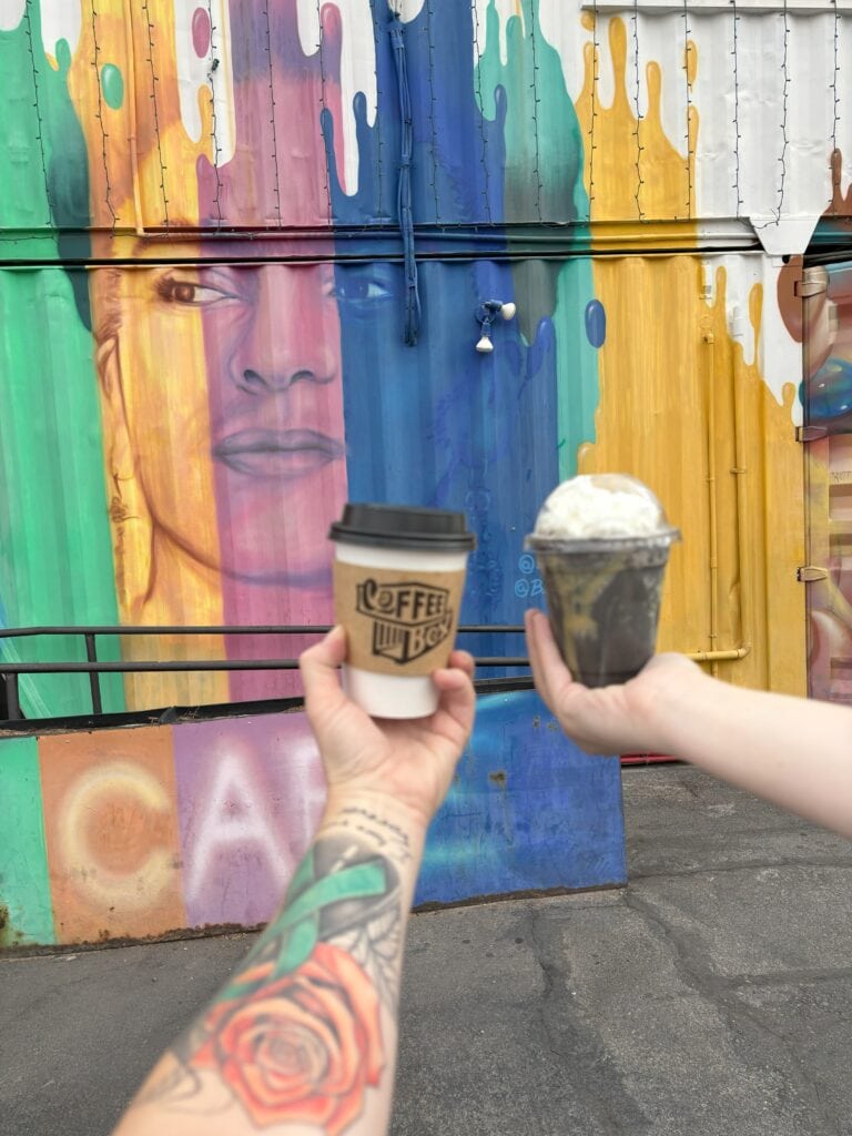 Coffee in front of a shipping container that is colorful