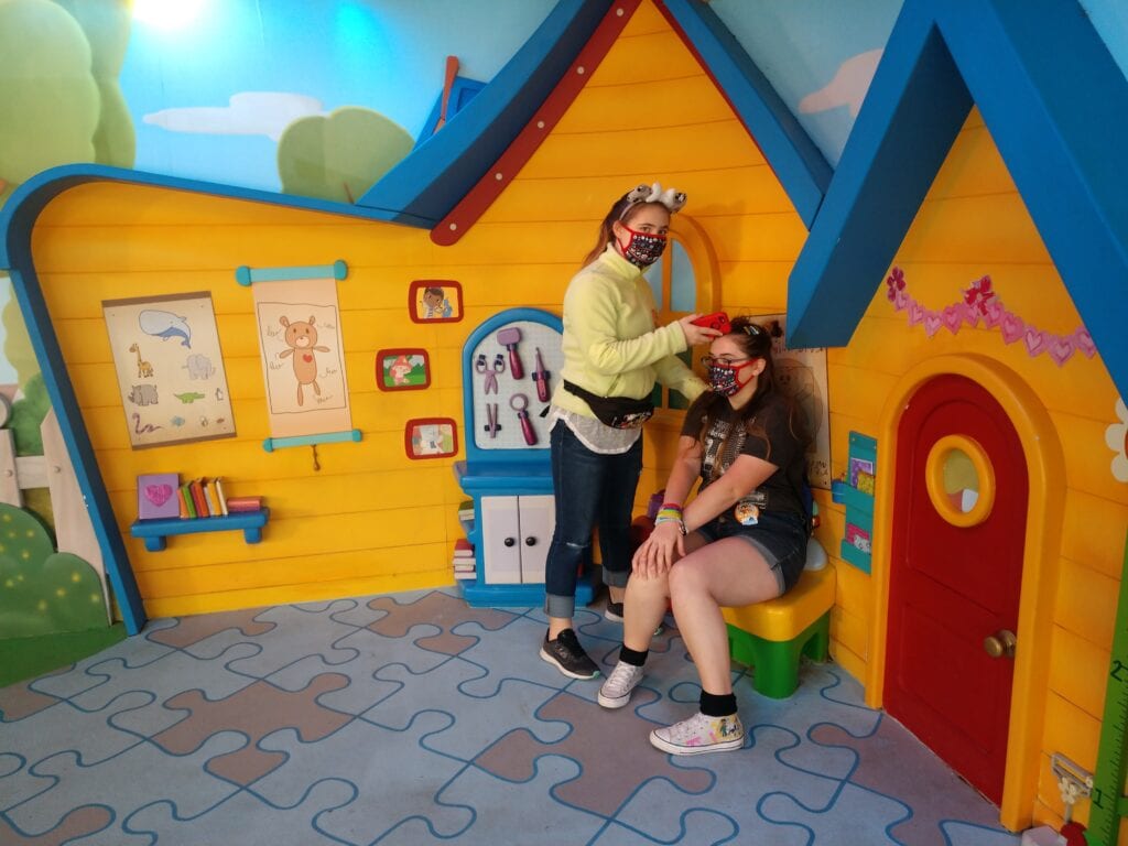 A girl "checking up" on her older sister at Doc McStuffins house in Hollywood Studios