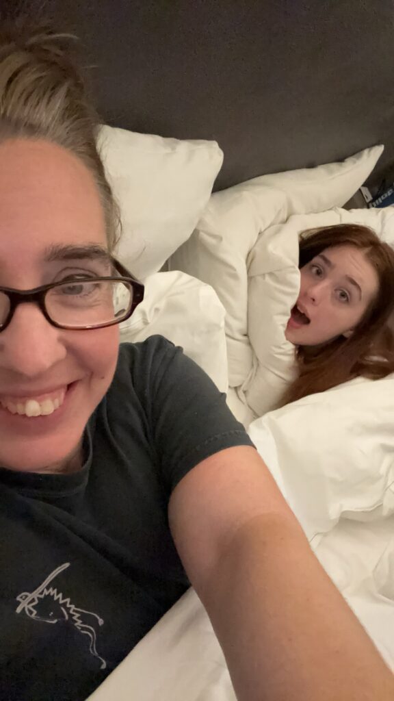 A mom and her daughter hanging out in a bed together 