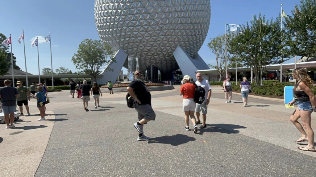 A man posing in front of spaceship earth