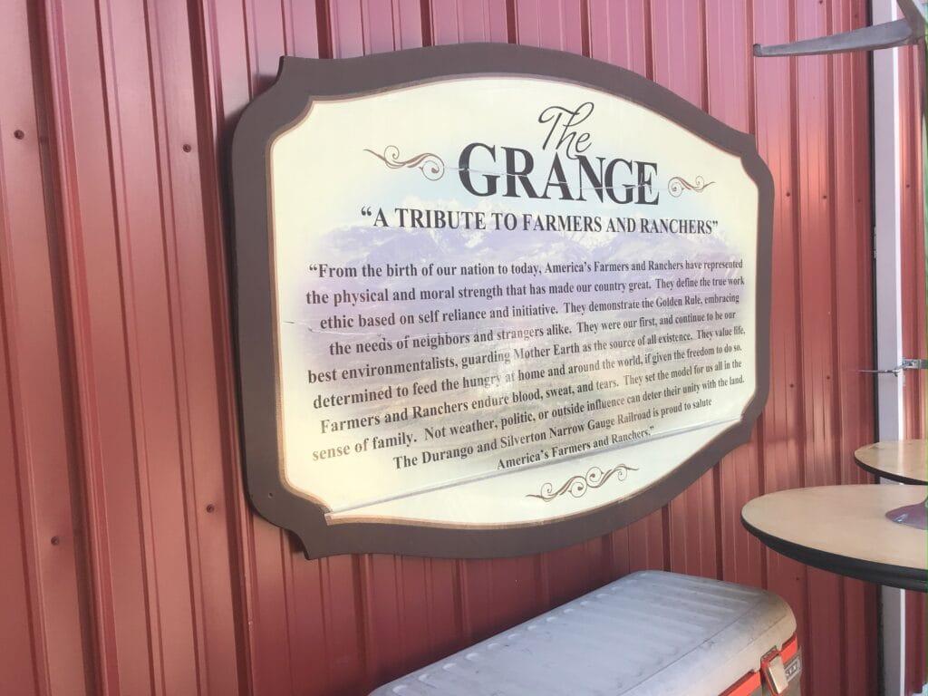 A sign saying "The Grange" and talking about honoring farmers