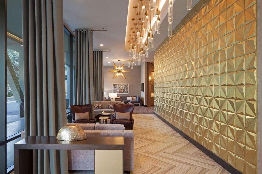 A hotel lobby with a gold wall and seating area